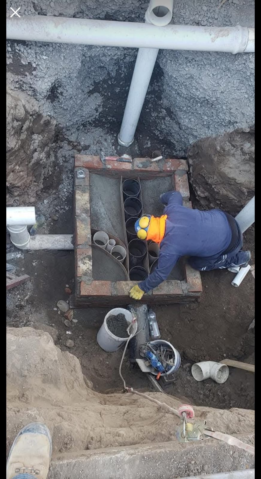 Hombre instalando tuberías de alcantarillado